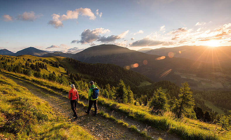 Wanderer auf Etappe 4 des Nockberge Trail mit Panorama über die Nockberge Richtung Falkertsee im UNESCO Biosphärenpark.