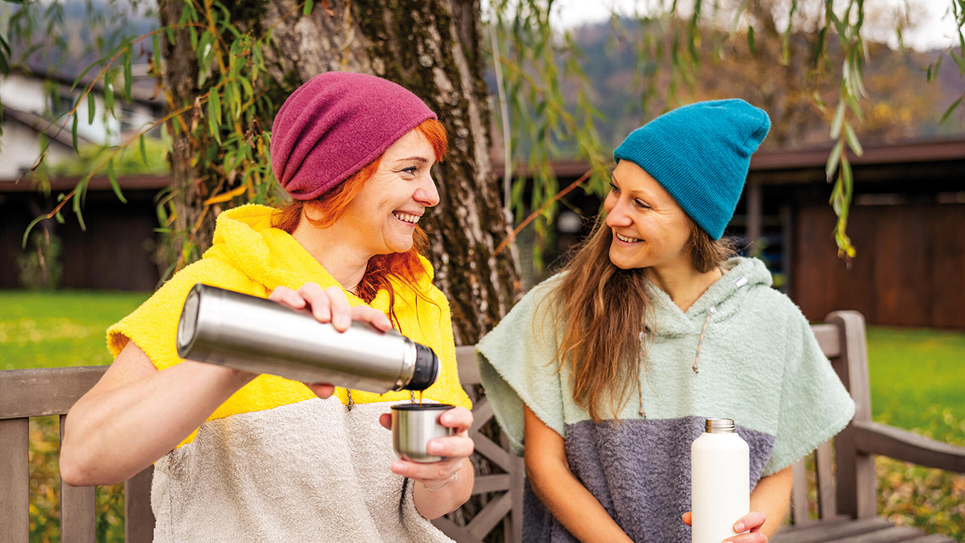 2 Frauen besprechen etwas mit Thermoskannen, bevor sie in den See kaltbaden gehen