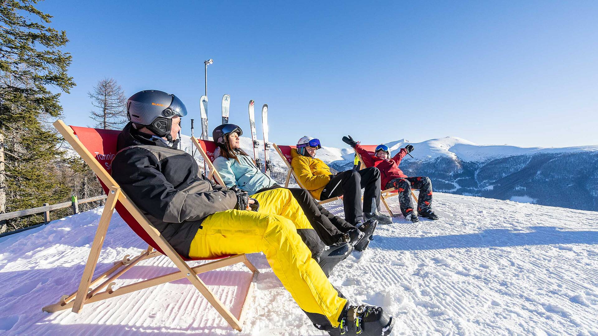 Personen sitzen in Liegestühlen und genießen die Sonne