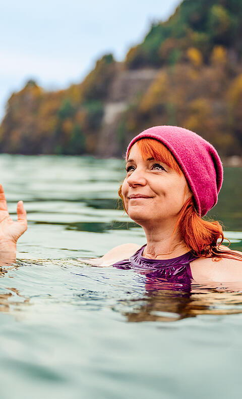 Frau ist mit Mütze im Herbst im Millstätter See Kaltbaden