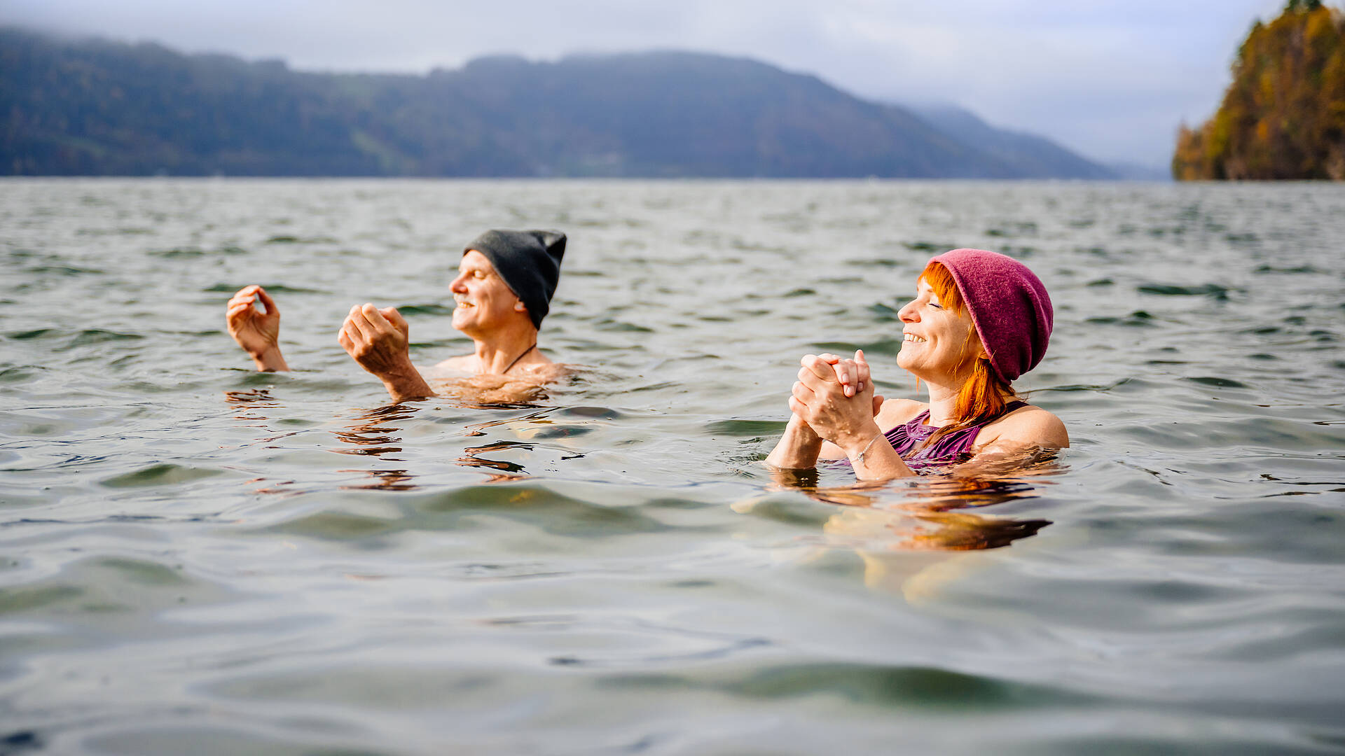 2 Personen sind mit Mütze im Herbst im Millstätter See Kaltbaden