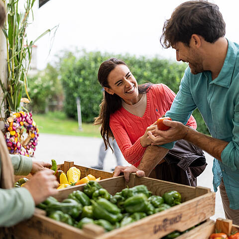 Pärchen schaut sich regionale Lebensmittel am Markt an